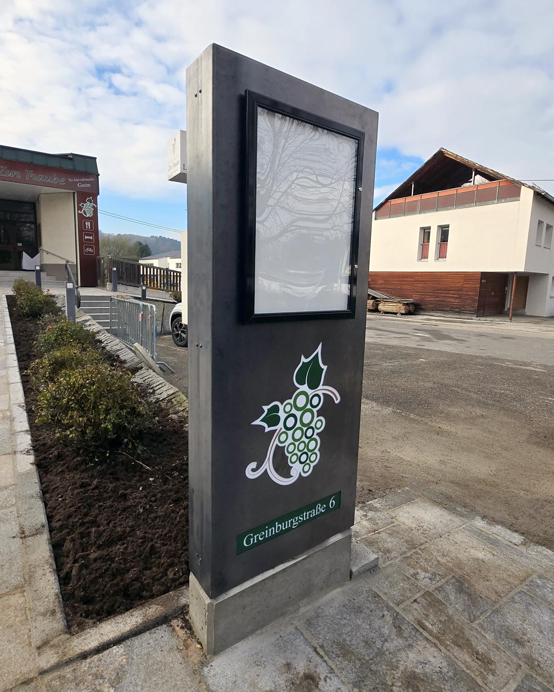 Werbepylon mit hinterleuchteten Acrylelementen und integriertem Schaukasten